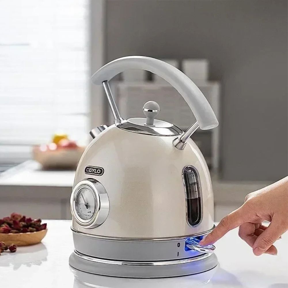 Bouilloire Sans Plastique 1,8L crème avec thermomètre analogique, allumée par une main.