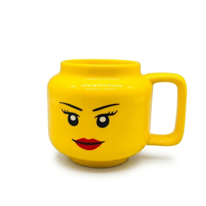 4626c009-f717-4e62-a9cd-3bf132bf565d.webp Mug en céramique jaune en forme de tête de personnage avec un visage souriant